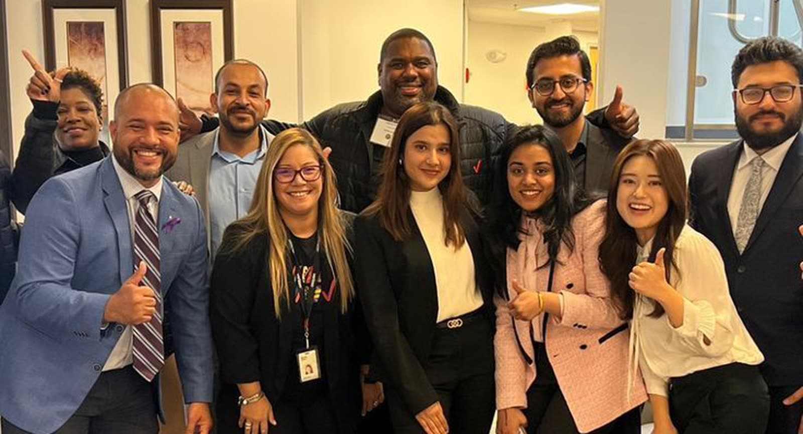 Grupo de personas reunidas y sonriendo en el interior de una oficina